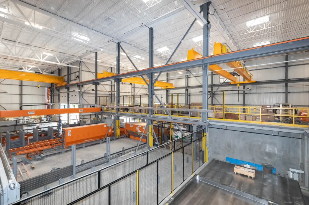 Precast wall component alongside a factory production line.